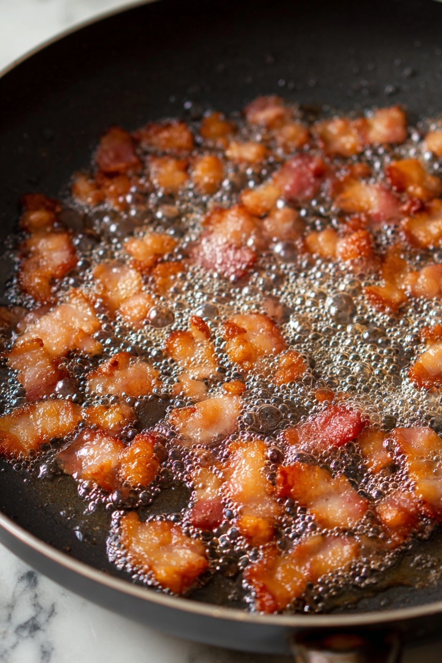The dish is shown in a white oval bowl filled with a colorful pea salad. The salad has three main layers mixed together: bright green peas that make up the bulk of it, small orange cubes of cheese scattered evenly throughout, and crispy dark red-brown bacon pieces spread on top and inside the mix. There are also thin beige almond slices sprinkled all over, adding texture. The salad is lightly coated with a creamy white dressing that slightly shines under the light. The bowl sits on a wooden board, with a silver spoon placed inside on the left side. A dark green cloth is partially visible on the left, and the whole setting is on a white marbled surface. photo taken with an iphone --ar 2:3 --v 7